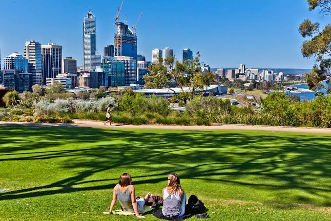 People relaxing on the grass in a city park